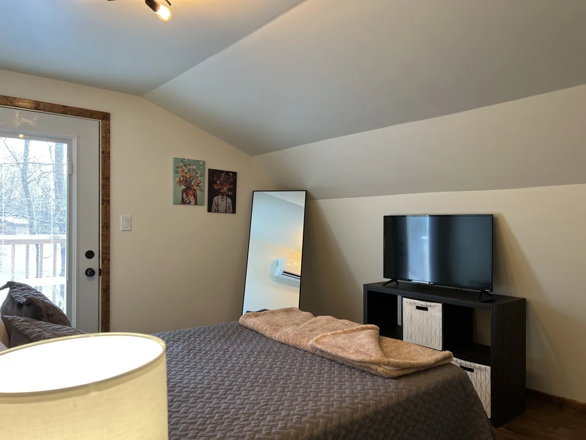 Bedroom at The Piedmont with a made bed and TV